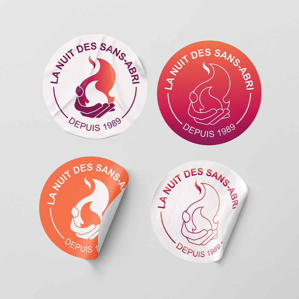 Stickers, autocolllant sur lesquels se trouve le logo de la Nuit des Sans-Abri. Logo moderne, circulaire, représentant une flamme. Palette de couleurs vives dans les teintes orange et aubergine.
