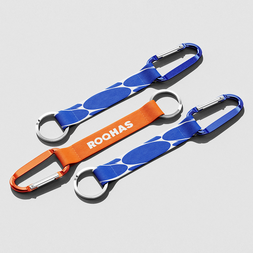 Déclinaison de l'identité visuelle sur des portes-clés promotionnels bleu et orange. Motif en forme de bulle de discussion.